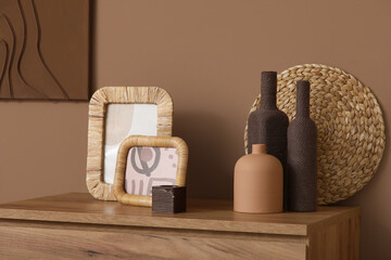 Stylish home decor on commode near brown wall in living room