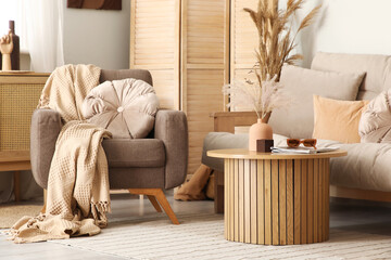 Interior of stylish living room with sofa, armchair and table