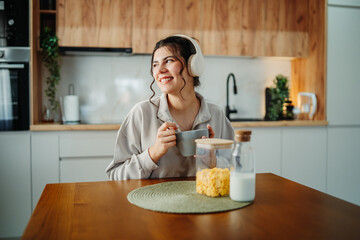 Young caucasian woman eating corn flakes for breakfast at home	