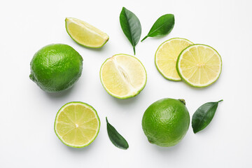 Fresh limes and leaves on white background, flat lay