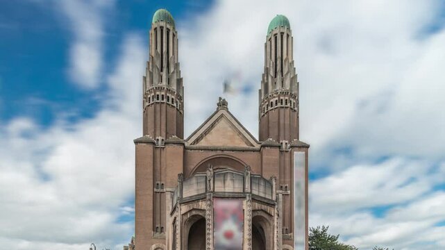 Timelapse hyperlapse of the National Basilica of the Sacred Heart in Brussels, Belgium. A Roman Catholic Minor Basilica with an Art Deco design, seen front view with stairs under a cloudy sky