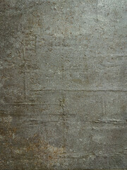 A textured gray concrete wall shows signs of age with cracks, stains, and uneven surfaces creating a rough, industrial aesthetic