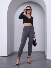 Fashion model poses elegantly in a modern studio setting showcasing contemporary style