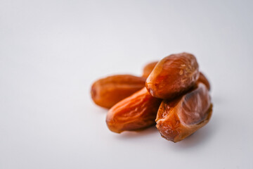 Top view of five dried dates arranged diagonally on a light cream background. Simple organic food layout, perfect for packaging, healthy eating, or clean food concepts
