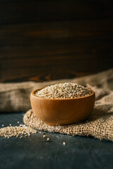 Steel-cut oats in a wooden bowl placed on rustic burlap fabric. Healthy organic cereal grains displayed with natural textures in warm, earthy tones