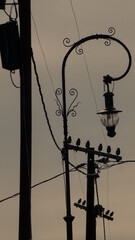 Antiguo tendido eléctrico y columna de luz al lado de la vía
