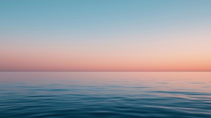 Obraz premium A calm ocean with gentle waves under a pastel-colored sky at sunset or sunrise.