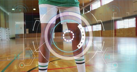 Female athlete standing on gym court, wearing knee support while digital sports HUD overlaying data - Powered by Adobe