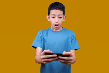 Teen Boy Play Racing App on Mobile Cell Phone for Video Games Isolated on Yellow Background