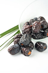 Dates fruit ajwa or kurma ajwa, in bowl isolated on white background