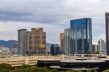 Obraz premium Modern Skyscrapers in Honolulu Against a Cloudy Hawaiian Skyline
