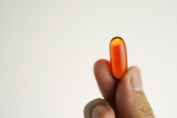 Male hand holding Oil filled capsules, softgel of food supplements, fish oil, omega 3, vitamin E