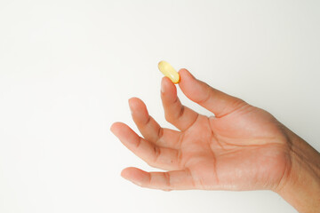 Male hand holding soft gels, Fish oil capsules, omega 3, omega 9, vitamin D, vitamin E, supplements