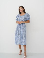 Elegant model showcasing floral dress in a modern studio setting