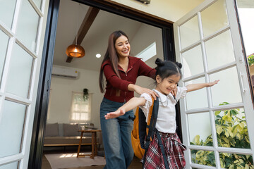 Excitement and Anticipation. A mother joyously sends her daughter off to school with encouragement.