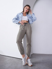 Stylish woman poses gracefully in trendy athleisure outfit during studio shoot