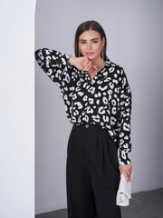 Fashion model showcases elegant studio look with a modern twist in monochrome ensemble
