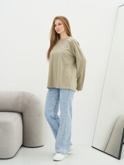 Fashionable woman posing in modern studio with minimalist decor and natural light