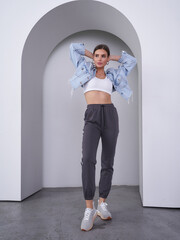 Stylish female model confidently poses in a minimalist studio reflecting modern trends