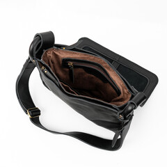 Naklejka premium Blank and open black leather sling bag isolated on white background, perfect for leather product catalogue