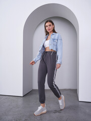 Fashion-forward female model showcasing stylish casual wear in a modern studio setting
