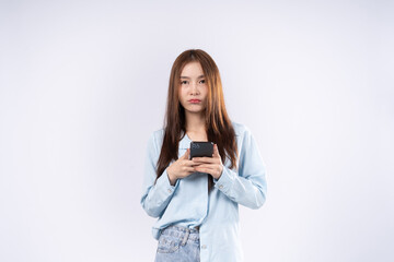 Fototapeta premium Woman using smartphone with dissatisfied expression photo in studio on white background