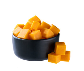 cheddar cheese cut into cubes in black bowl isolated on white background .