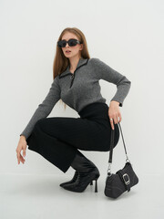 Striking fashion model poses on a minimalistic studio backdrop showcasing elegance