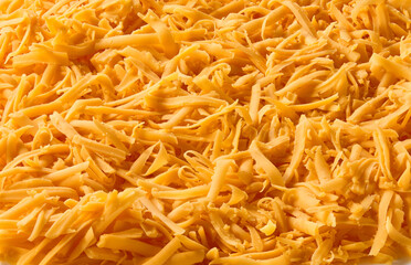 texture of grated cheddar cheese, food background.