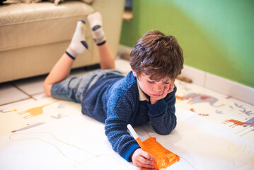 Child engaged in creative drawing on the floor