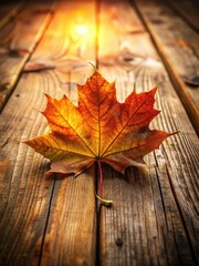 Obraz premium Fall maple leaf on wooden table with warm golden light cast