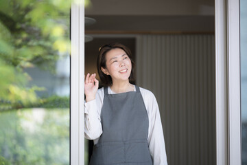 Woman with apron like a housewife looking out the window Lifestyle and second life
