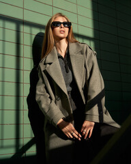 Striking pose by a female model in stylish coat under dramatic lighting