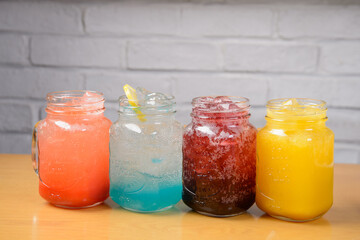Different colored drinks in 4 clear cups
