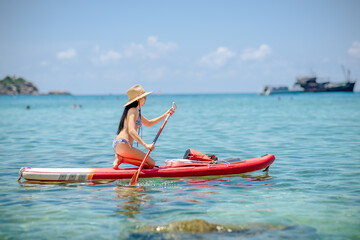Fototapeta premium Woman tourist enjoy paddleboard at the sea summer, vacation long weekend traveling