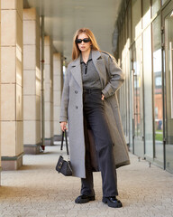 Obraz premium Elegant female model showcases modern fashion in a chic urban studio setting