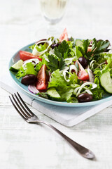 Healthy and tasty salad with feta cheese, various tomatoes, olives, cucumber, onion and lettuce.	