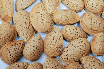Shelled almonds are creating a beautiful textured background on a light blue surface, perfect for...