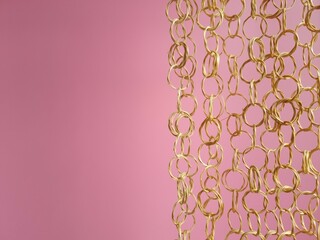 Decorative chains of wooden rings on a pink background close-up
