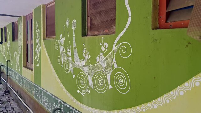 A video of traditional Warli art beautifully painted on the exterior walls of a village school
