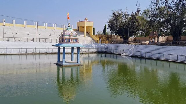 A video of a small temple amidst a Pushkarani or Kalyani pond with an intricate stepped design