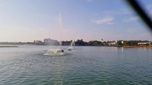 A video of water fountains or jets in a reservoir, pumping water high into the sky during dusk