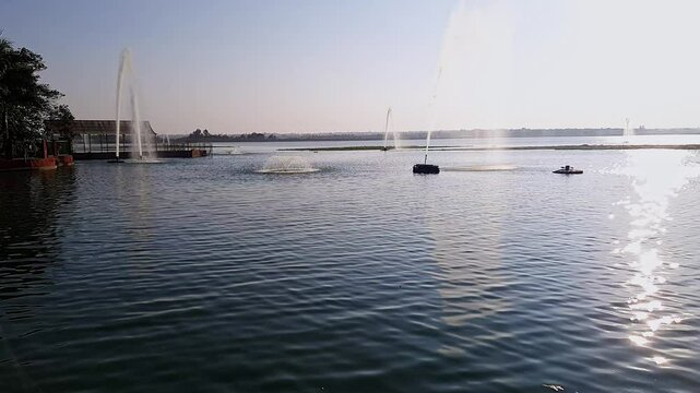 A video of water fountains or jets in a reservoir, pumping water high into the sky during dusk