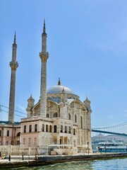 Fototapeta premium Ortaköy Mosque on the Bosphorus waterfront with minarets and bridge in Istanbul, Turkey