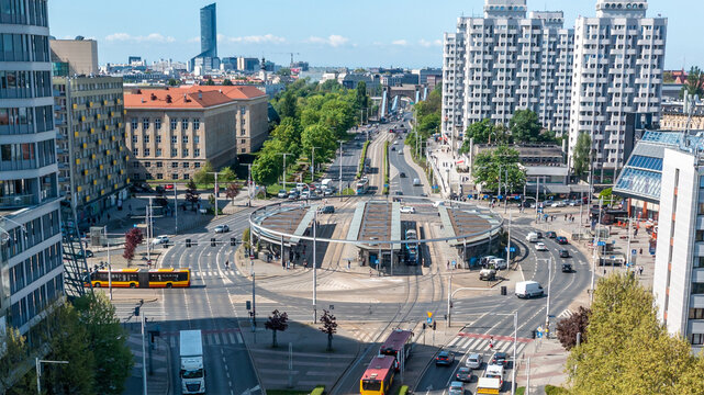 Wide view of city intersection and public transportation hub surrounded by modern and historic buildings, depicting urban mobility and architecture - Powered by Adobe
