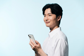 夏の日差しの中にいる、白シャツを着た黒髪の日本人男性