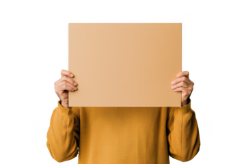 A person in a yellow sweater holds a blank cardboard sign covering their face.
