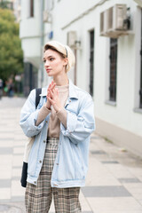 Fototapeta premium young beautiful woman posing in blue jacket outside