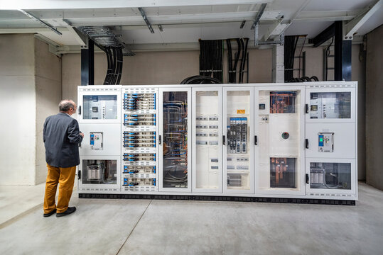 Manager inspecting control panel in industrial production hall