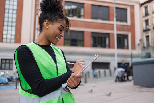Volunteer writing on a clipboard during an outdoor campaign